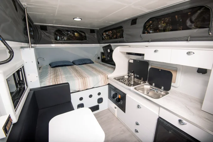 blue tongue camper xc16 hybrid caravan interior showing bed kitchen and dining set up